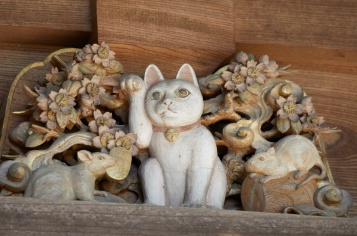 Gotokuji three-story pagoda zodiac cat carving sitting alongside the rat