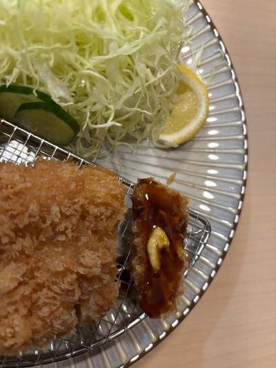 Dipping tonkatsu in special sauce at Horiichi